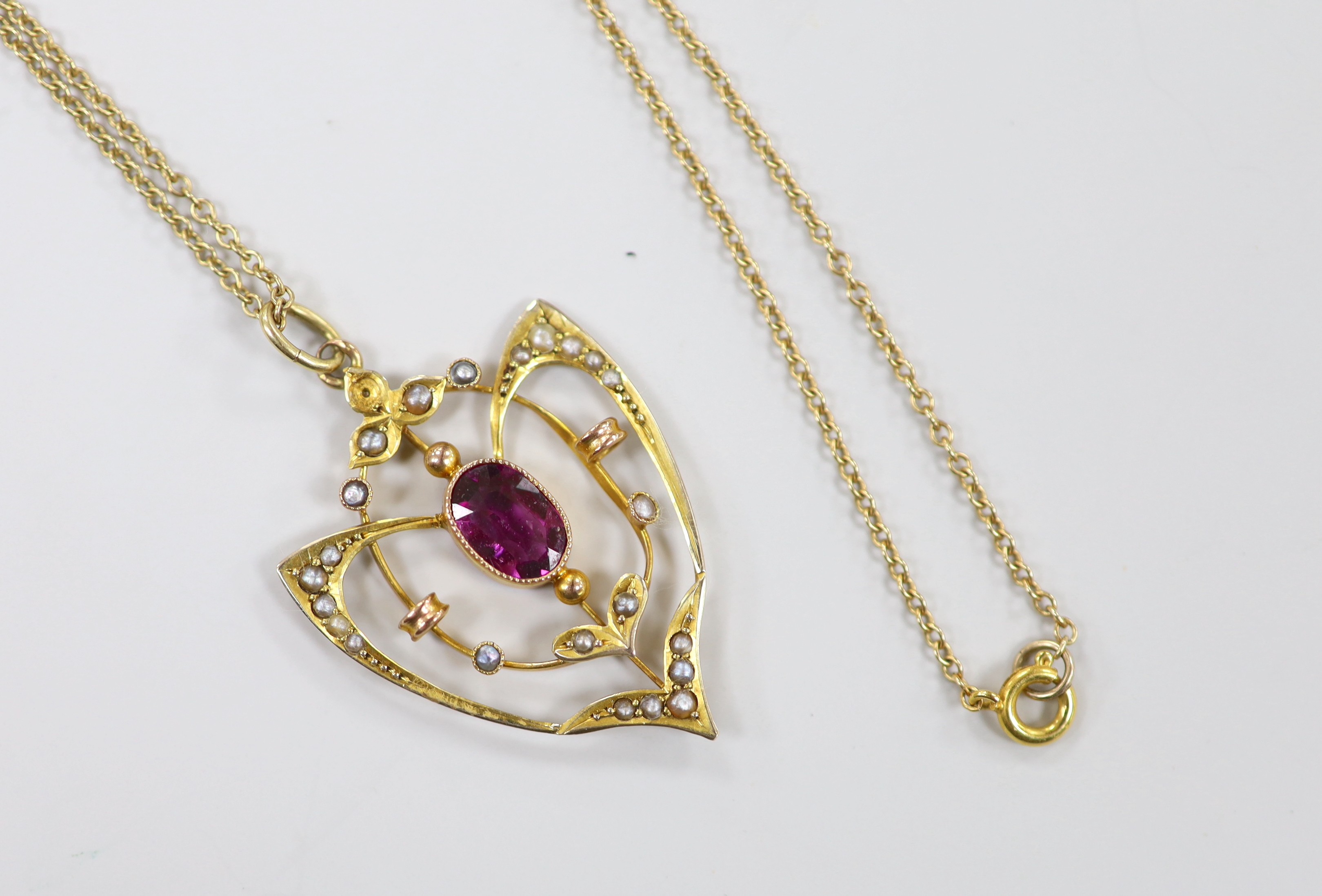 An Edwardian 9ct, garnet and seed pearl cluster set pendant, 33mm, on a later 9ct chain, 39cm, gross weight 3.7 grams.